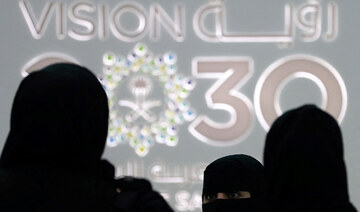 Saudi women stand next to the Saudi pavilion (vision 2030) at the Gitex 2018 in Dubai on October 16, 2018. (AFP)