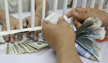 A customer counts Philippine peso after selling US dollars at a money changer in Manila on September 8, 2008. (AFP)