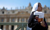 A nun holds a newspaper with an image of Pope Francis in St. Peter's Square, as Pope Francis continues hospitalization.