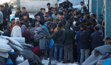 Palestinians gather to receive aid provided by UNRWA including food supplies.