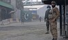 Afghan security personnel, right, and Pakistani border policemen stand guard at the Torkham border crossing.