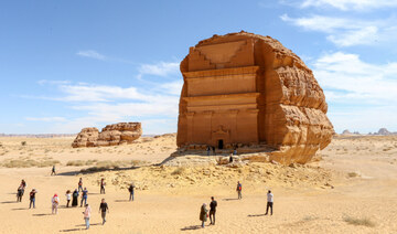 Visitors are seen in front of Qasr al-Farid tomb at the Madain Saleh antiquities site in Al-Ula, Saudi Arabia. (REUTERS)