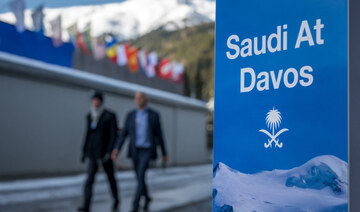 Attendees walk past a sign of the Saudi representation at the annual meeting of the World Economic Forum in Davos. (AFP)